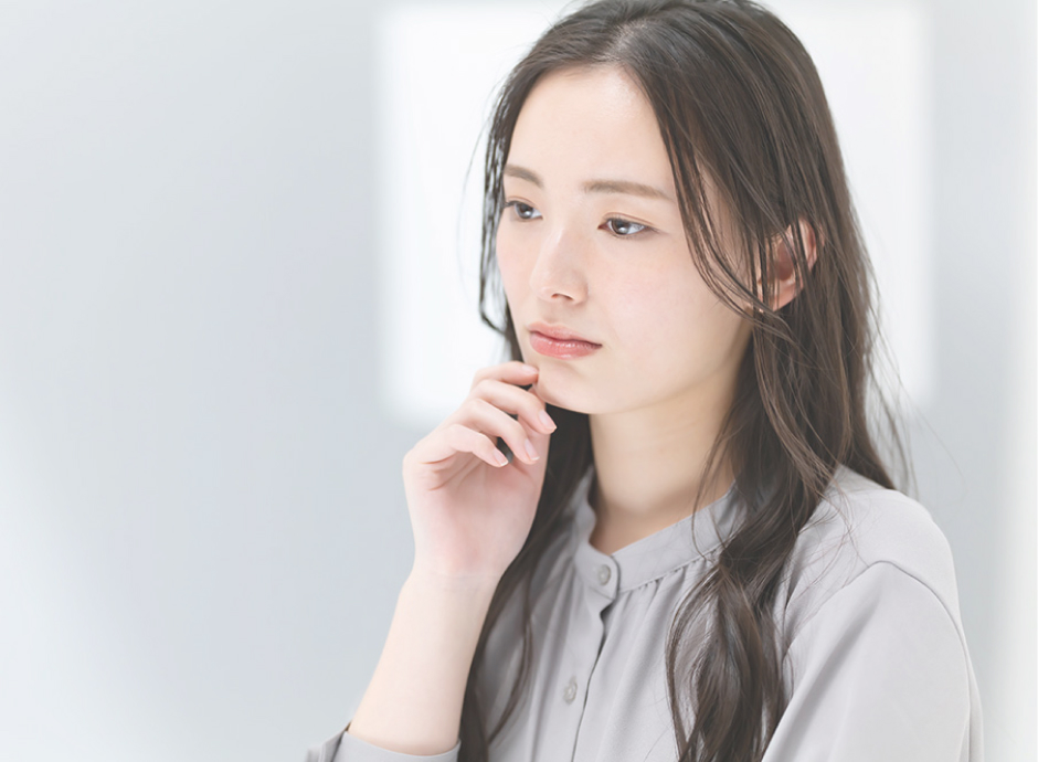 顎に手を当てて考えこむ女性の様子
